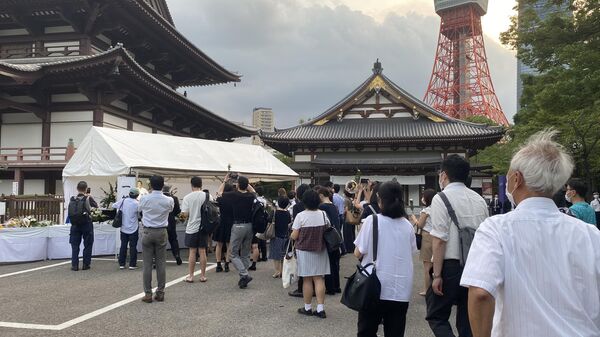 Люди на церемонии прощания с бывшим премьер-министром Японии Синдзо Абэ в буддийском храме Дзодзёдзи в центре Токио