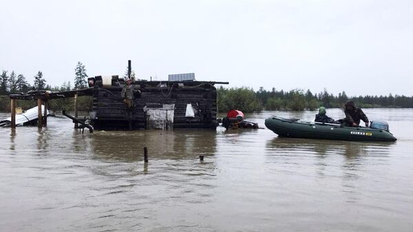 Сотрудники МЧС РФ эвакуируют людей из подтопленной в результате паводка территории села Томтор в Якутии