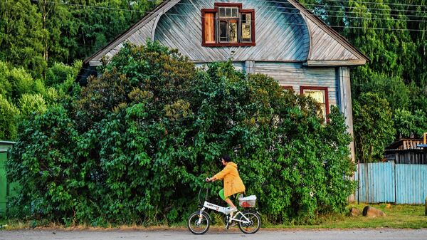 Женщина едет на велосипеде на одной из улиц Галича