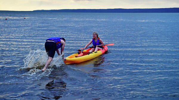 Молодые люди плавают на байдарке на Галичском озере в Костромской области