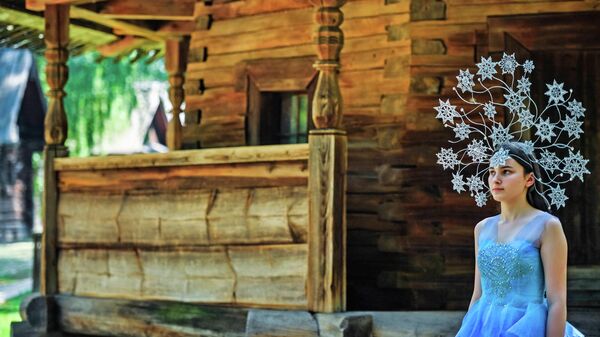 Девушка демонстрирует кокошник, изготовленный мастером Еленой Серовой, во время фотосессии на территории музея деревянного зодчества Костромская слобода в Костроме