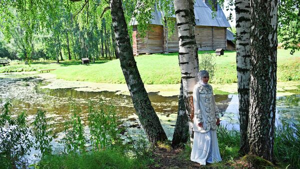 Девушка в костюме Снегурочки во время фотосессии на территории музея деревянного зодчества Костромская слобода в Костроме. Костюм и кокошник изготовлен мастером Еленой Серовой