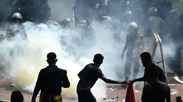 Военнослужащие используют слезоточивый газ для разгона демонстрантов во время антиправительственной акции протеста у офиса премьер-министра Шри-Ланки в Коломбо. 13 июля 2022