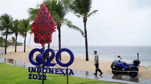 Полицейский проходит мимо вывески G20 в Нуса-Дуа, Бали
