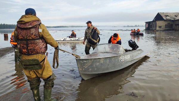 Сотрудники МЧС РФ эвакуируют людей из подтопленного в результате паводка села Бетенкес в Якутии