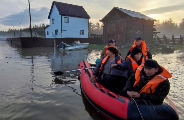 Сотрудники МЧС РФ эвакуируют людей из подтопленного в результате паводка села Бетенкес в Якутии