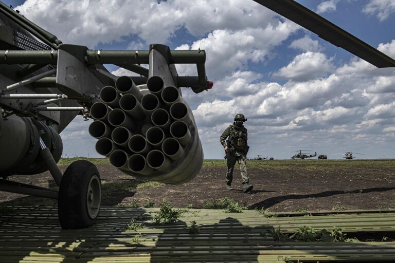 Военнослужащий у вертолета Ми-8МТВ на полевом аэродроме в зоне проведения специальной военной операции