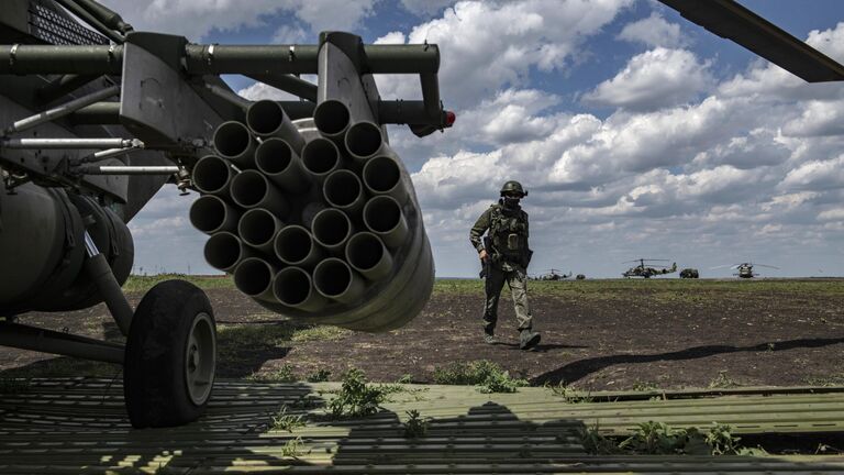 Военнослужащий у вертолета Ми-8МТВ на полевом аэродроме в зоне проведения специальной военной операции