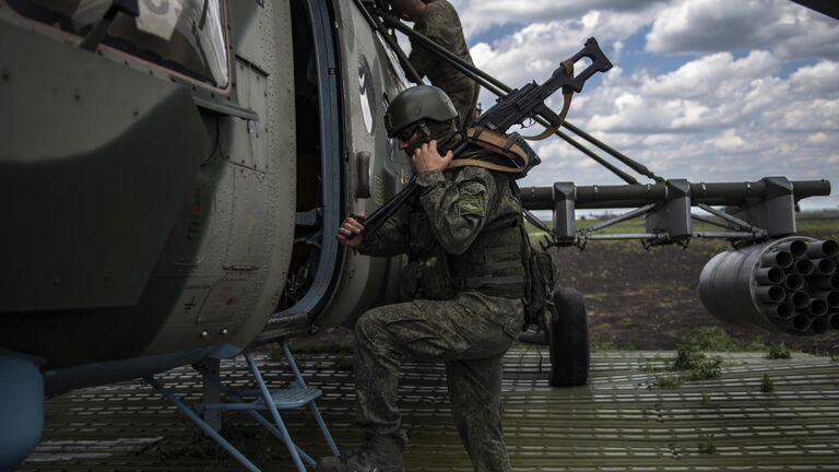 Военнослужащий у вертолета Ми-8МТВ на полевом аэродроме в зоне проведения специальной военной операции