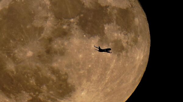 Самолет пролетает мимо полной луны в Милуоки