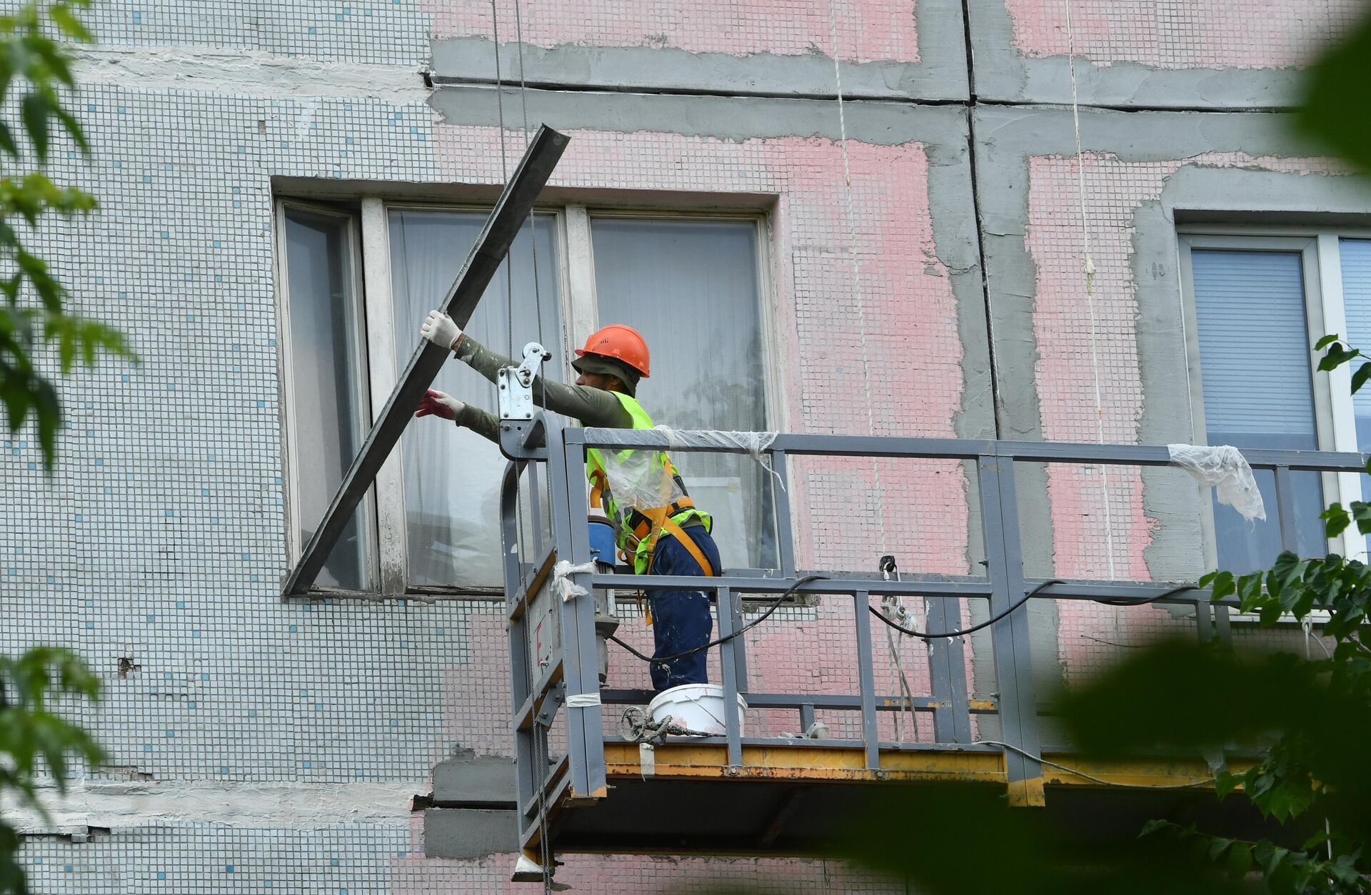 Рабочий во время восстановления фасада одного из самых длинных жилых домов Москвы по адресу Россошанская 1к1 - РИА Новости, 1920, 14.07.2022