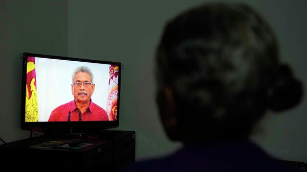 Женщина смотрит телевизионное выступление президента Шри-Ланки Готабая Раджапакса