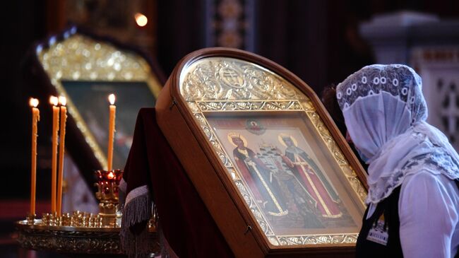 Верующая перед праздничной Божественной литургией в храме Христа Спасителя в день памяти святого равноапостольного князя Владимира и День Крещения Руси Верующая перед праздничной Божественной литургией в храме Христа Спасителя в день памяти святого равноапостольного князя Владимира и День Крещения Руси