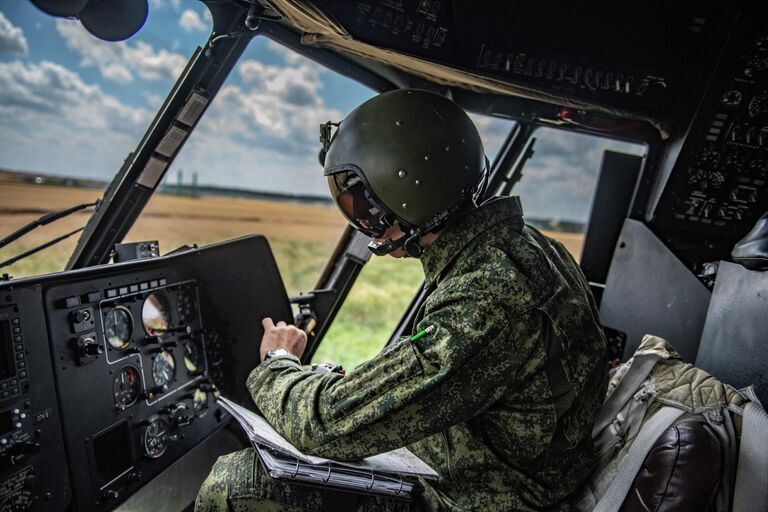 Военный летчик в кабине вертолета Ми-8МТВ на полевом аэродроме в зоне проведения специальной военной операции