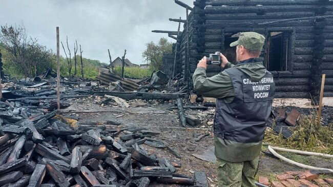 Сотрудник Следственного комитета на месте пожара в селе Колбинка Томской области