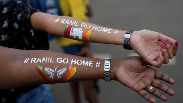 Надписи на руках девушек Ранил, иди домой, относящиеся к премьер-министру Ранилу Викремесингхе