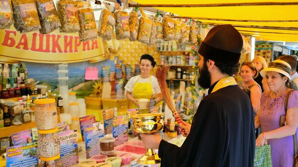 Священник освящает прилавок с медом на ярмарке меда в Краснодарском крае