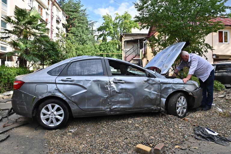 Мужчина у автомобиля, пострадавшего из-за сильного наводнения, на Донской улице в Сочи