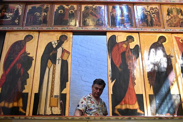 Монтажник устанавливает отреставрированные иконы в соборе Покрова Пресвятой Богородицы на Рву в Москве