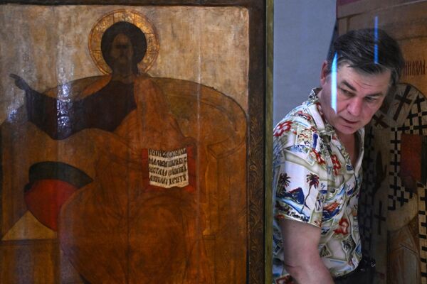Монтажник устанавливает отреставрированные иконы в соборе Покрова Пресвятой Богородицы на Рву в Москве