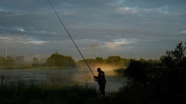 Мужчина ловит рыбу вблизи деревни Стан Тверской области
