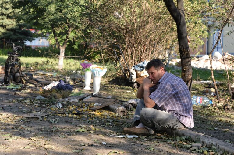 Мужчина на месте гибели родственника в Горловке, подвергшейся ракетно-минометному обстрелу.