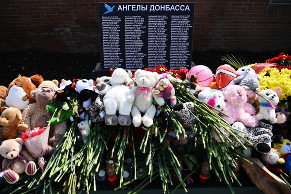 Игрушки и цветы у стенда, посвященного памяти жертвам Донбасса на площади Донецкой Народной Республики в Москве