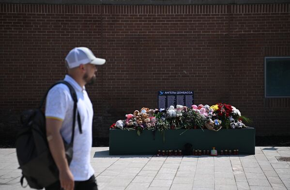 Игрушки и цветы у стенда, посвященного памяти жертвам Донбасса на площади Донецкой Народной Республики в Москве
