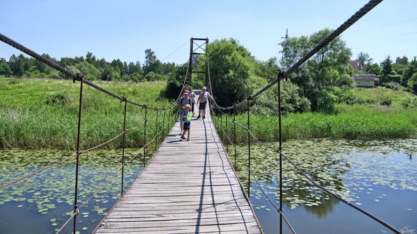 Подвесной пешеходный мост через реку Лава в городе Правдинске