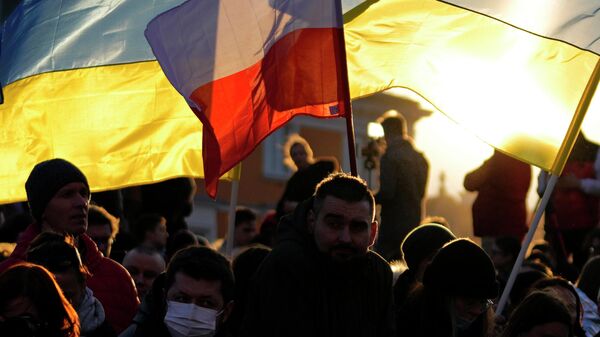 Люди с флагами Польши и Украины в Варшаве