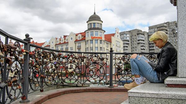 Девушка сидит на пешеходном разводном мосту Юбилейный в Калининграде