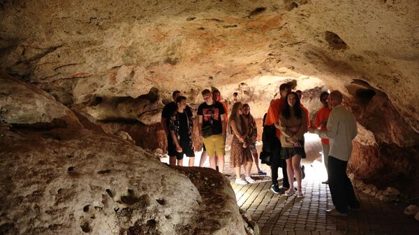 Посетители на экскурсии в пещере Таврида, расположенной в районе поселка Зуя в 20 километрах от Симферополя в Крыму