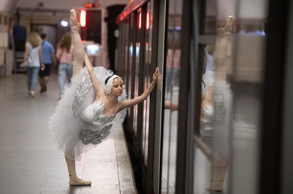 Артистка балета перед началом ночного концерта на станции метро Новослободская в Москве