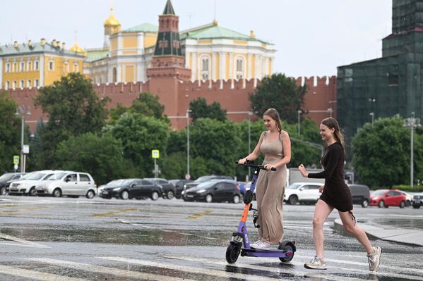Девушки переходят улицу по лужам в Москве Девушки переходят улицу по лужам в Москве