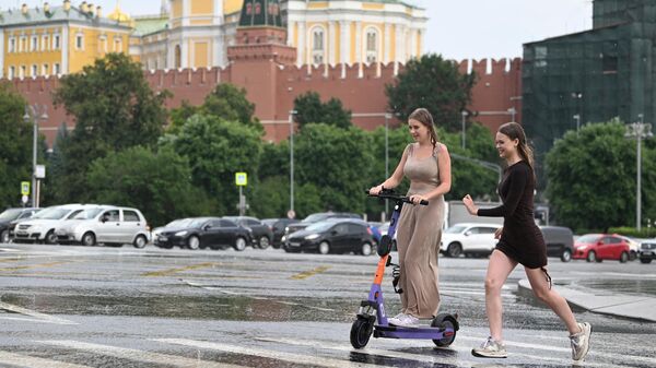 Девушки переходят улицу по лужам в Москве