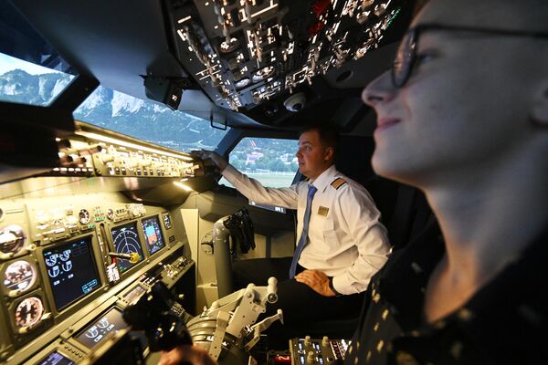 Молодой человек и пилот во время занятия на авиатренажере Dream Aero, расположенном на территории торгово-развлекательного центра РИО Дмитровка Молодой человек и пилот во время занятия на авиатренажере Dream Aero, расположенном на территории торгово-развлекательного центра РИО Дмитровка