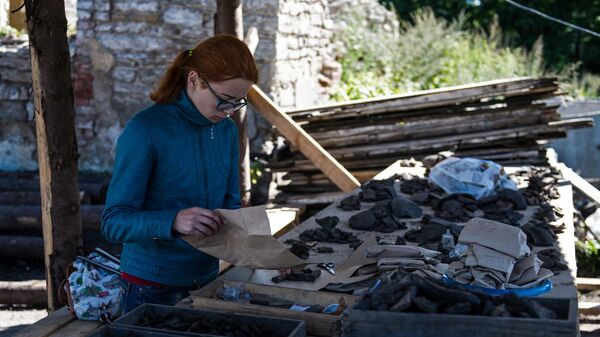 Девушка рассматривает археологические находки в Пскове