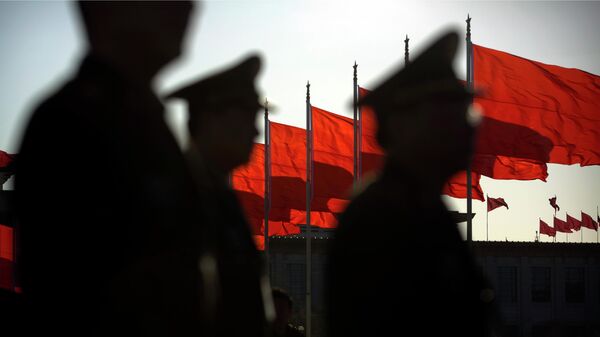 Военнослужащие Народно-освободительной армии Китая на фоне государственных флагов