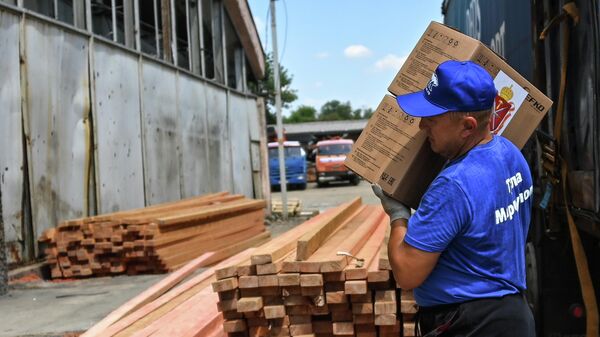 Рабочий разгружает гуманитарную помощь от жителей Тулы для жителей Мариуполя