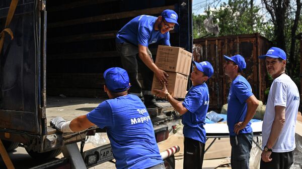 Рабочие разгружают гуманитарную помощь от жителей Тулы для жителей Мариуполя