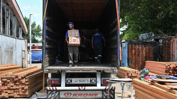 Рабочие разгружают гуманитарную помощь от жителей Тулы для жителей Мариуполя