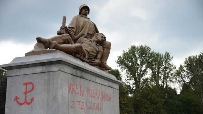 Надписи красной краской на пьедестале одной из скульптур мемориального комплекса на кладбище-мавзолее советских воинов в Варшаве. 19 сентября 2017