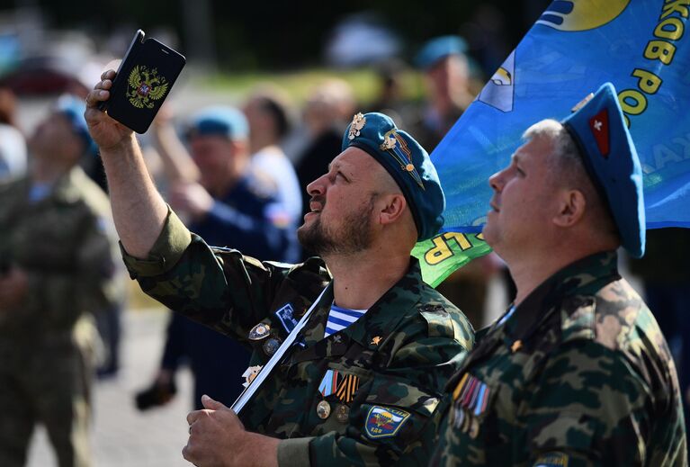 Десантники фотографируют показательные прыжки спортсменов-парашютистов на набережную Городского пруда в Екатеринбурге в День ВДВ