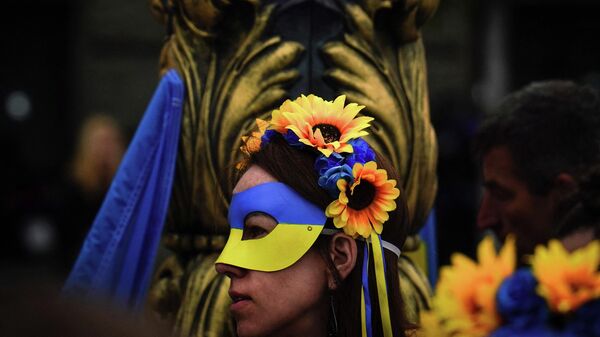 Девушка в маске в цвет флага Украины во время акции протеста в Белграде 