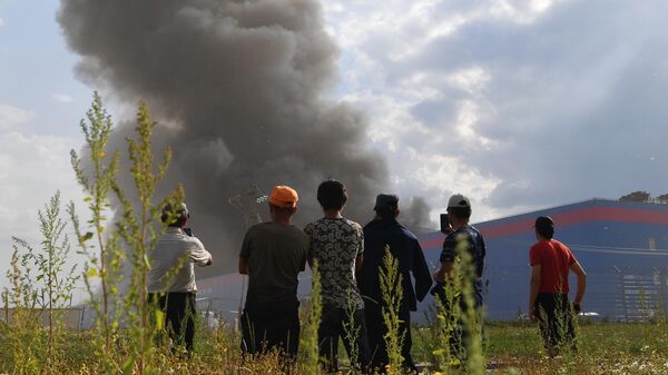 Люди наблюдают за пожаром на складе OZON в Истринском районе Подмосковья