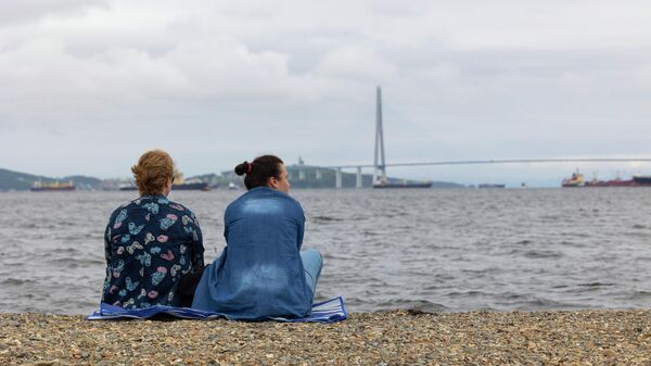 Туристки любуются мостом на остров Русский