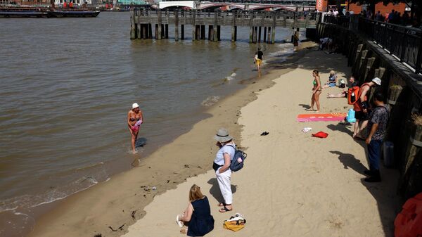 Жители Лондона отдыхают на берегу Темзы в жаркую погоду