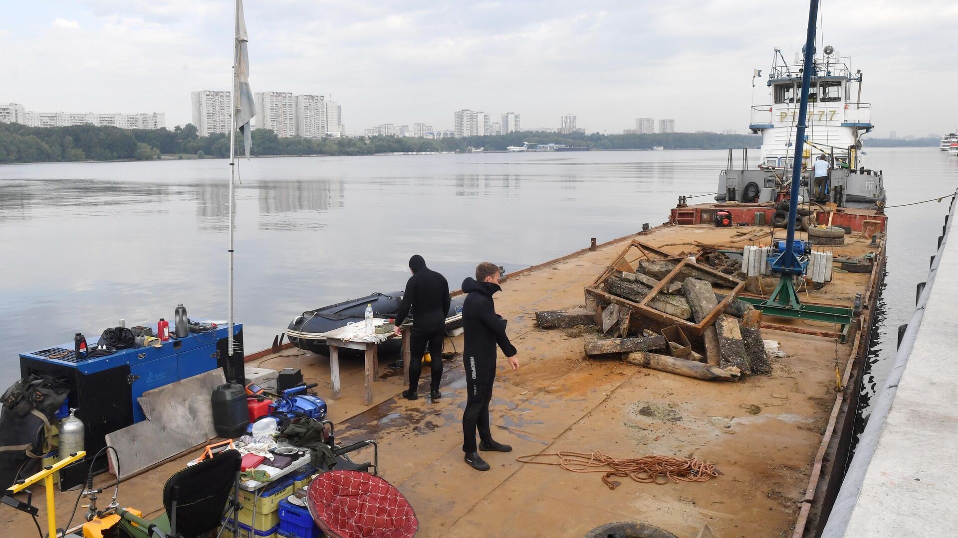 Водолазы на барже с собранным мусором во время работ по очистке дна причалов Северного речного вокзала на берегу Химкинского водохранилища в Москве - РИА Новости, 1920, 05.08.2022