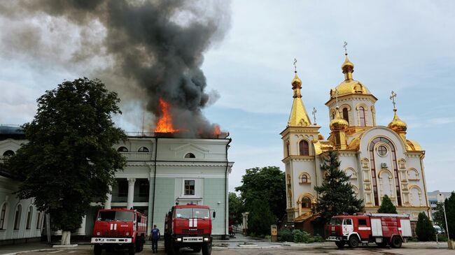 Сотрудники противопожарной службы МЧС ДНР тушат пожар в здании железнодорожного вокзала в Донецке