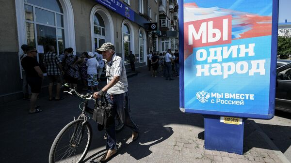 Жители Бердянска стоят в очереди у входа в пункт приема документов на гражданство Российской Федерации